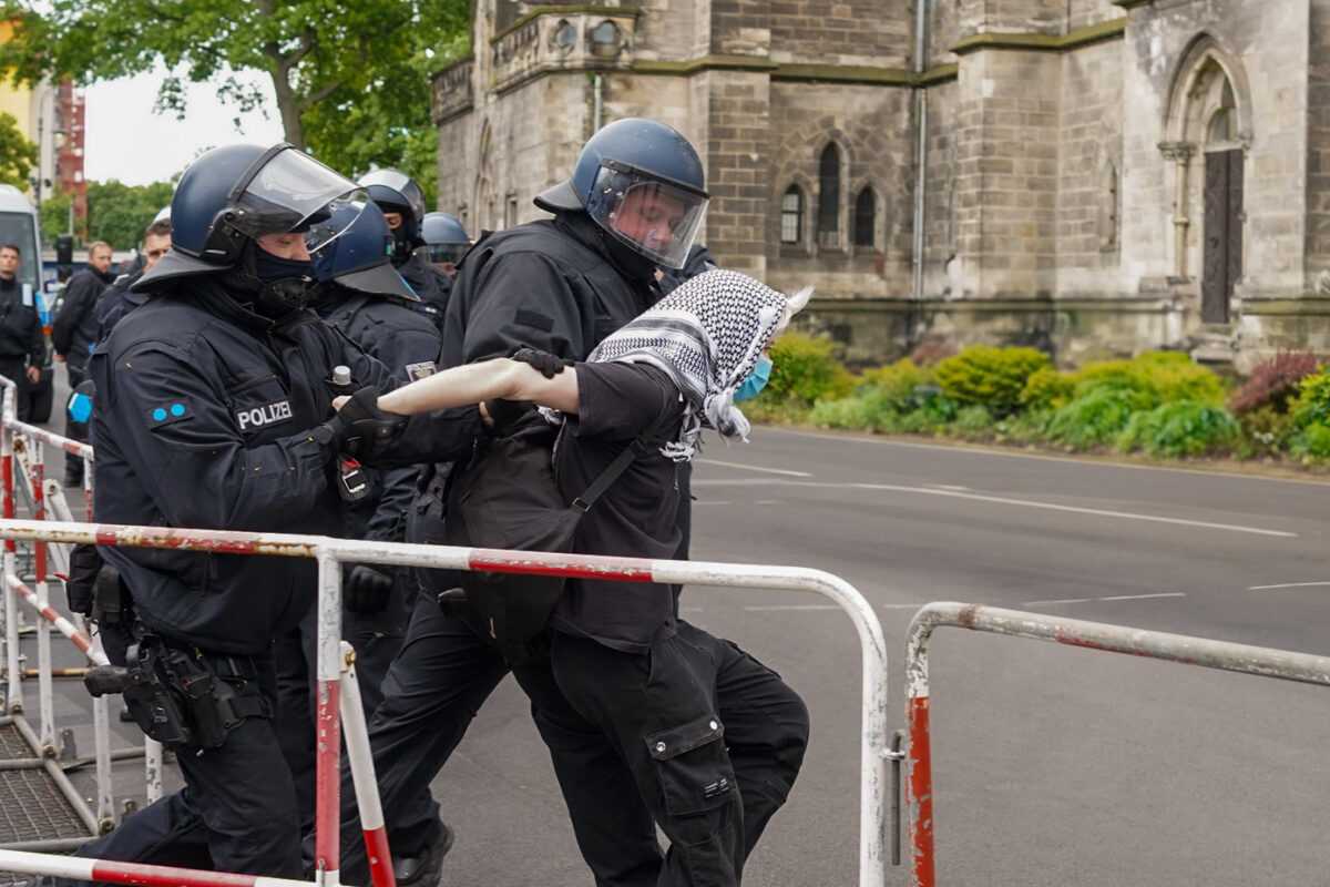 Police violently pull demonstrator from crowd.