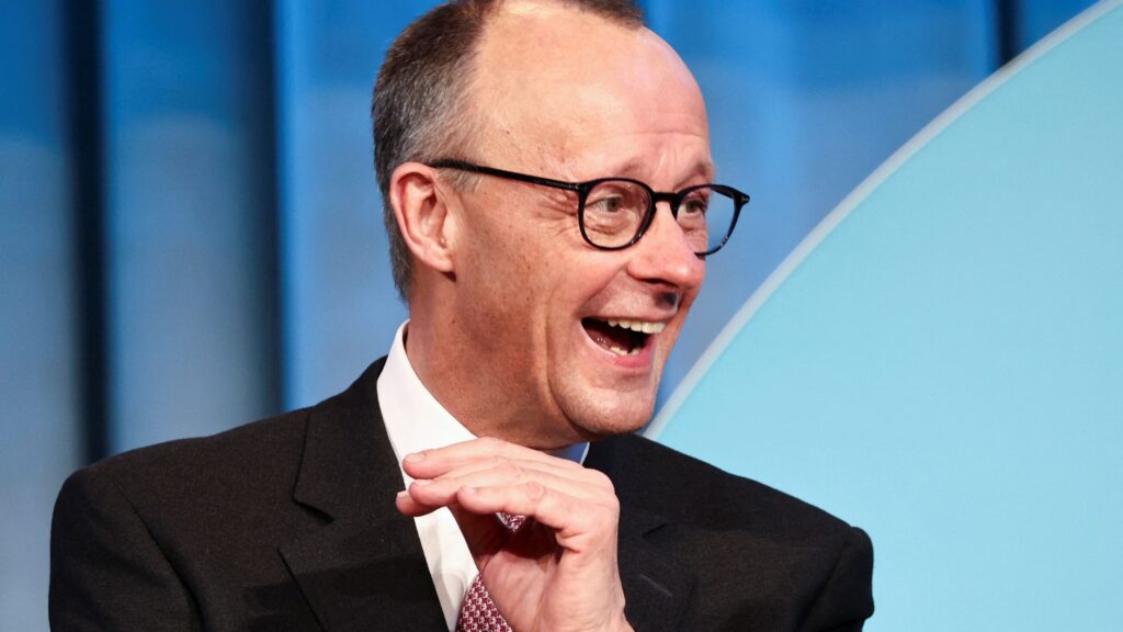 Friedrich Merz laughing at something off-camera.
