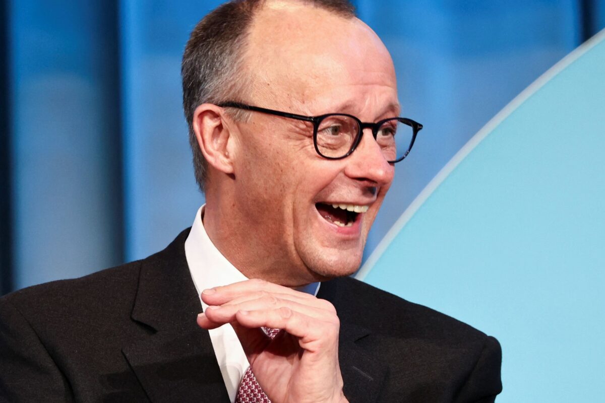 Friedrich Merz laughing at something off-camera.