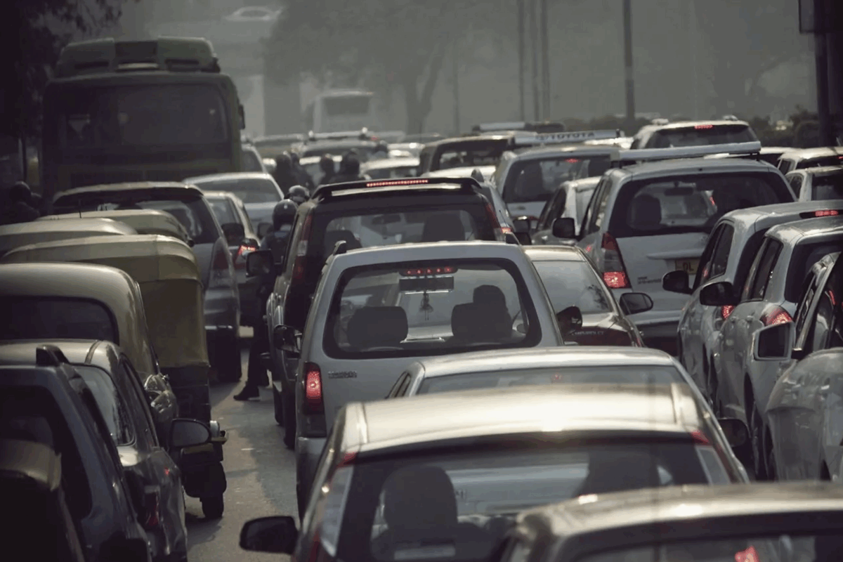 View from behind a sea of cars, as if viewer was also stuck in a car in traffic.