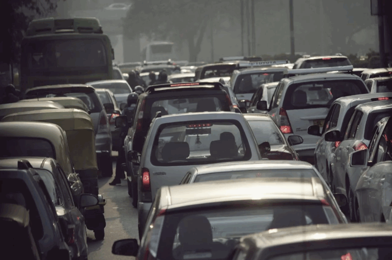 View from behind a sea of cars, as if viewer was also stuck in a car in traffic.