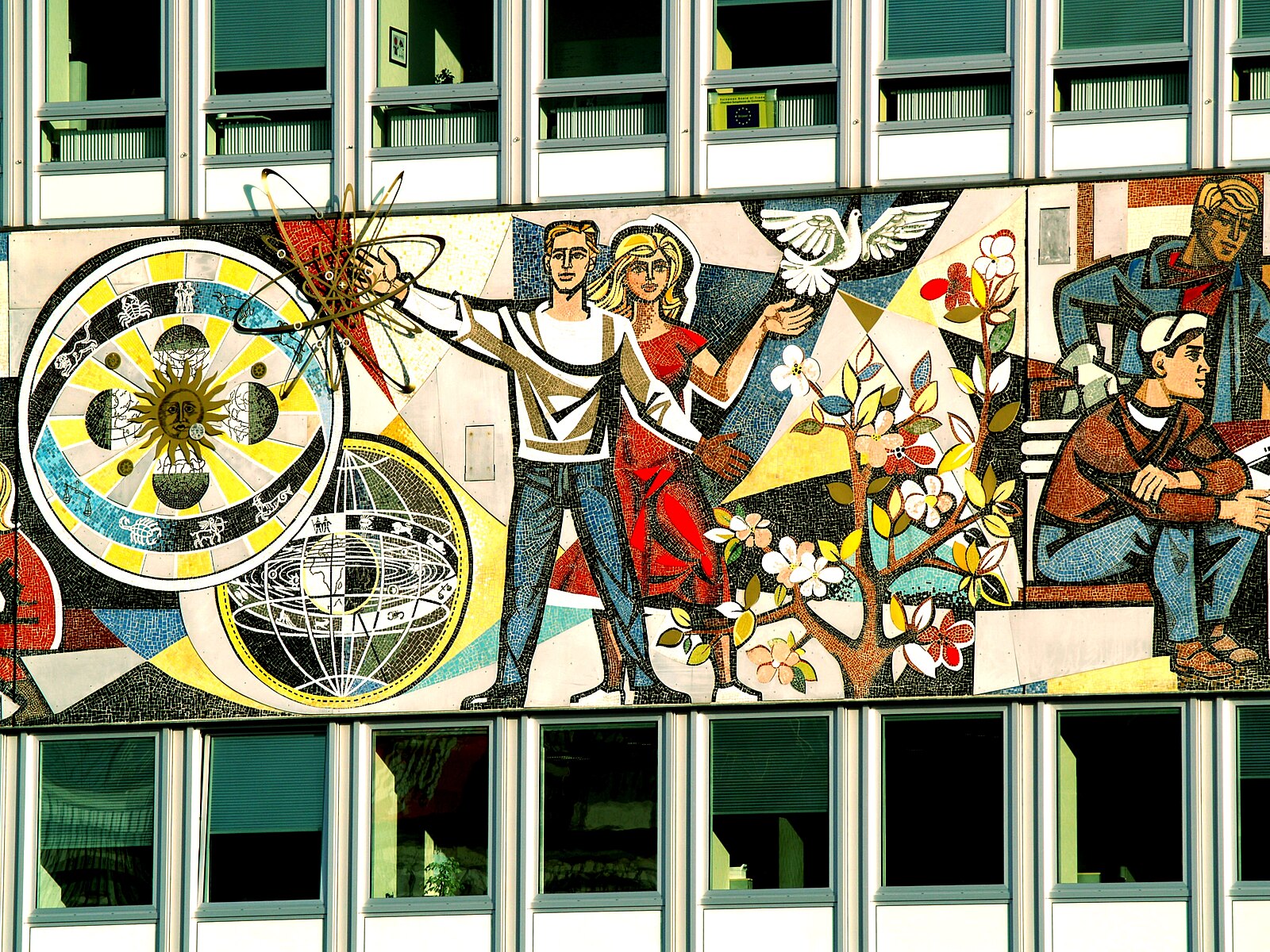 A mural depicting a socialist utopia: two smiling people with symbols of science and advancement swirling around them.