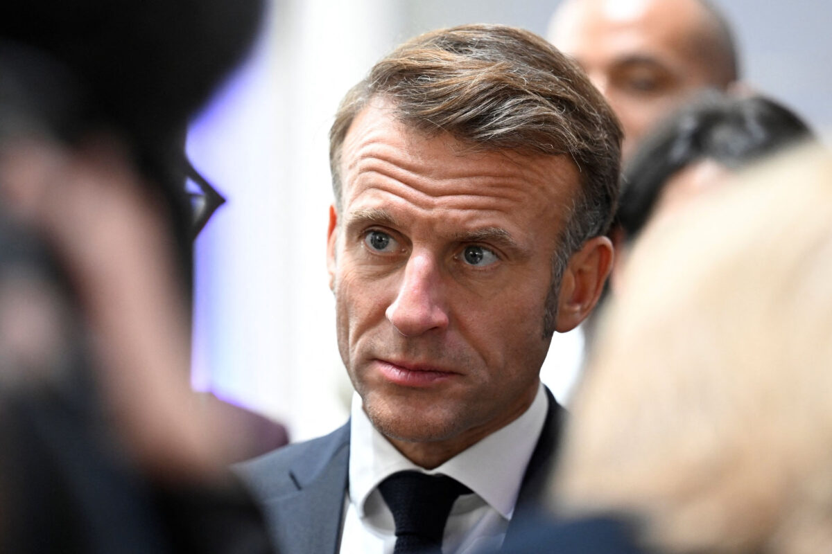 President Emmanuel Macron stares, seemingly concerned, through a crowd.