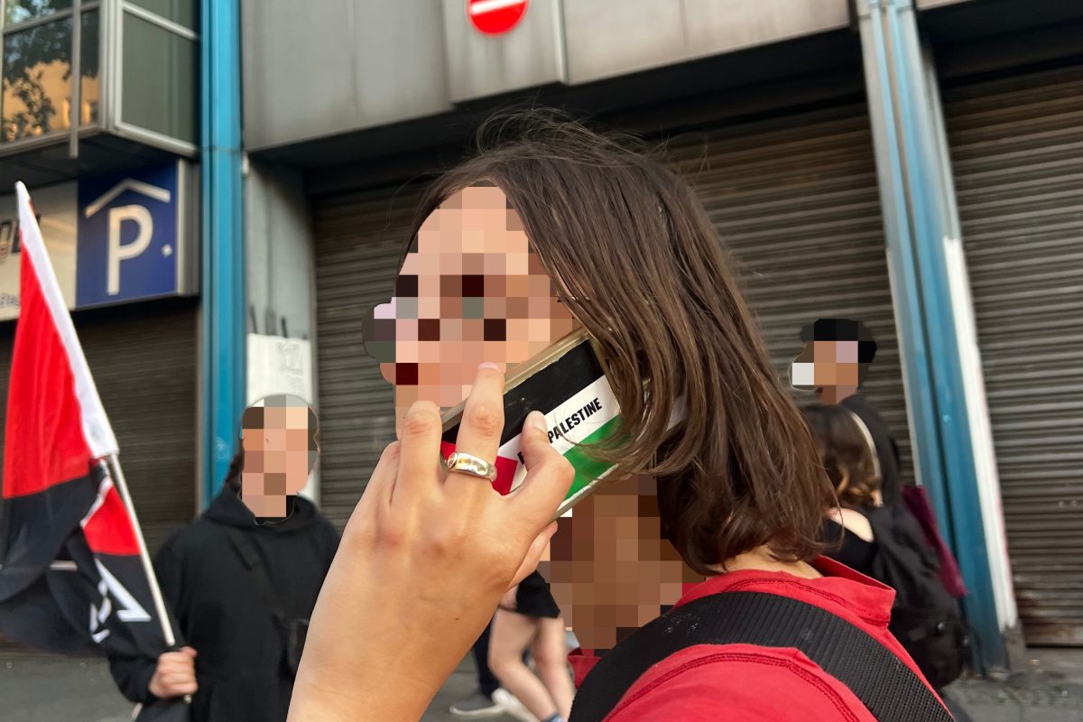 Pro Palestine Berliner on their cell phone with blurred face