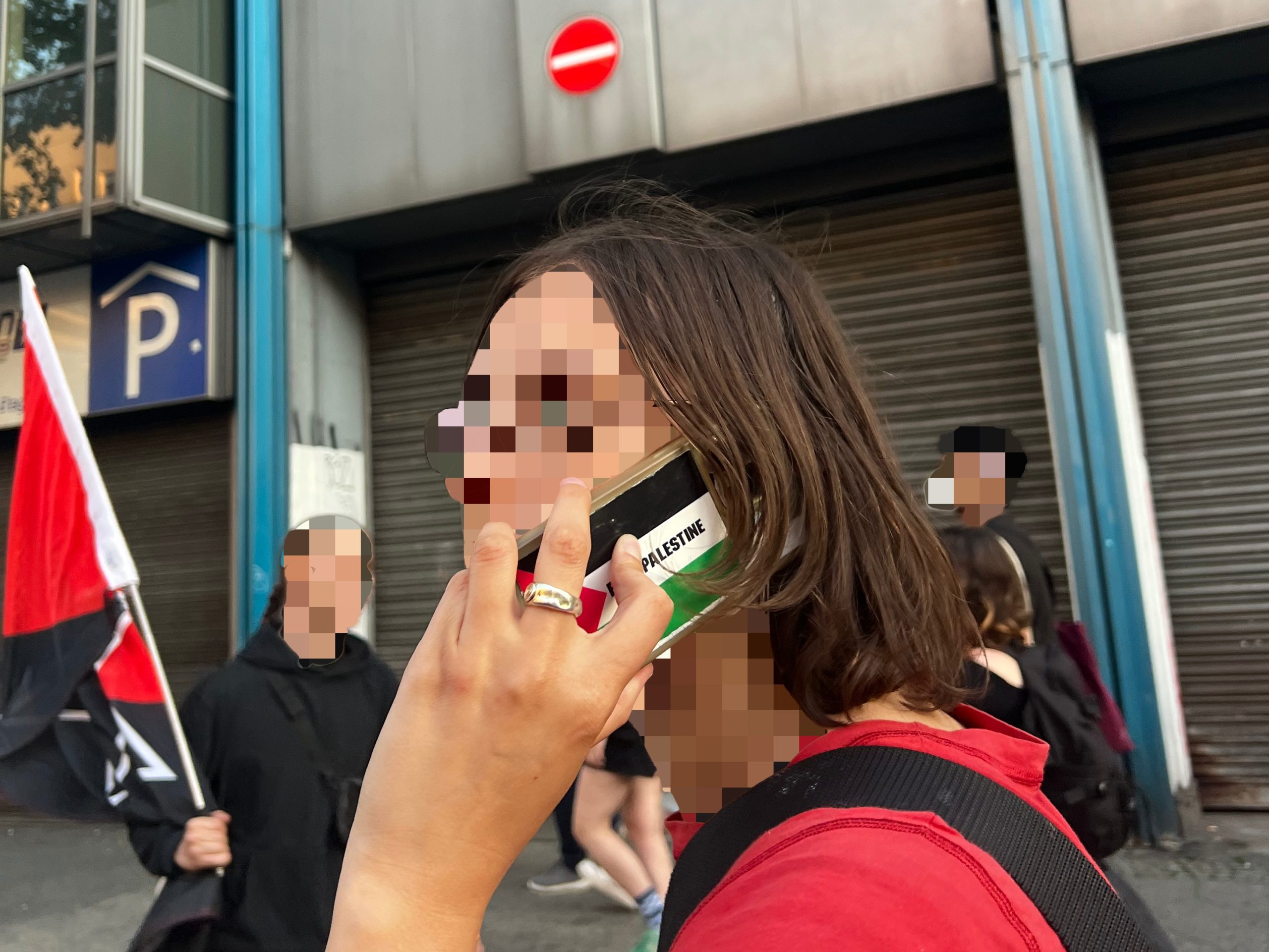 Pro Palestine Berliner on their cell phone with blurred face