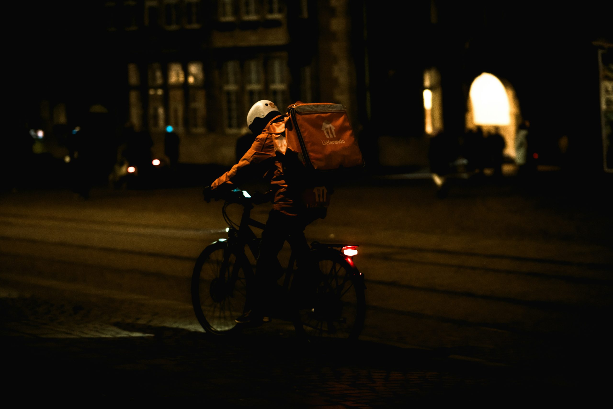 A food delivery driver rides at night