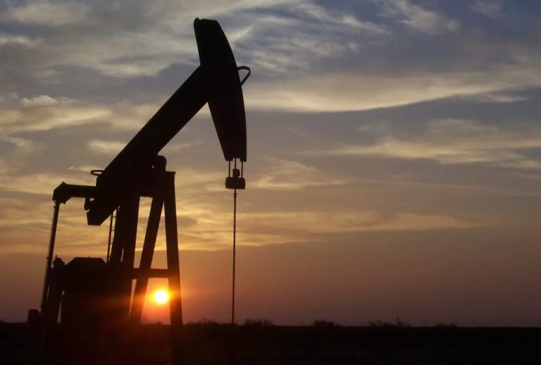 The silhouette of an oil rig against a sunset